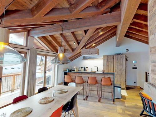 - une cuisine avec des plafonds en bois et une table avec des tabourets dans l'établissement Chalet de Luxe à Saint Martin de Belleville : Spa, Sauna, Proche Pistes et Commerces - FR-1-452-199, à Saint-Martin-de-Belleville