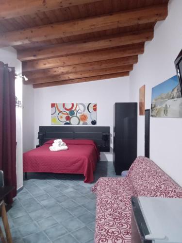 a bedroom with a red bed and a couch at Villa Lucia in Lampedusa