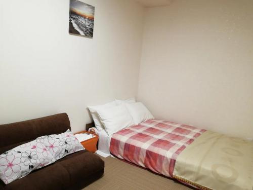 1 dormitorio pequeño con 1 cama y 1 sofá en Tokyo stay Hut SARI - Vacation STAY 27260v en Tokio