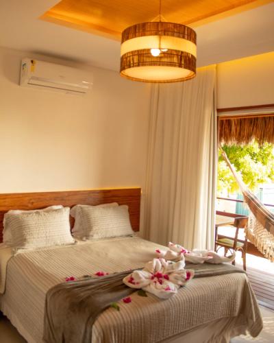 una camera da letto con un letto decorato con fiori di Junduh Brasil Pousada e Restaurante a Icaraí