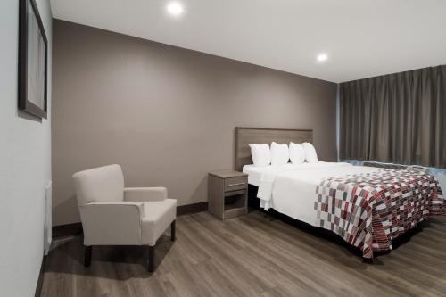 a hotel room with a bed and a chair at Red Roof Inn Rocky Mount - Battleboro in Battleboro