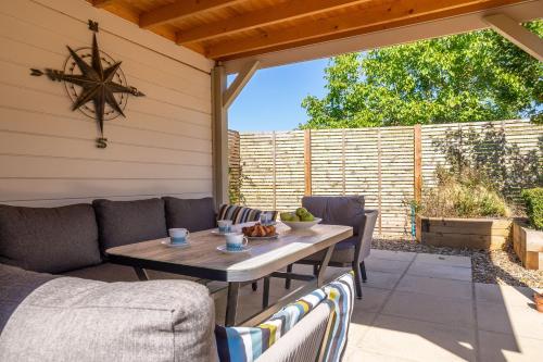 a patio with a wooden table and chairs at Yew Tree Cottage in Westleton