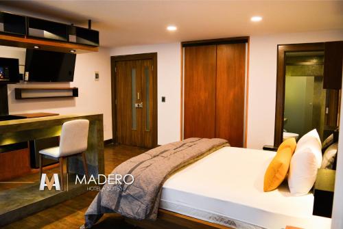 a bedroom with a bed and a desk and a kitchen at Madero Hotel & Suites in La Paz