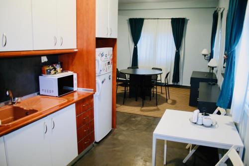 een keuken met een wastafel en een keuken met een tafel bij REM House in Thessaloniki