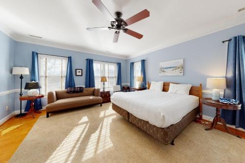 a bedroom with blue walls and a bed and a couch at Town of Rehoboth Beach 314 Laurel St in Rehoboth Beach
