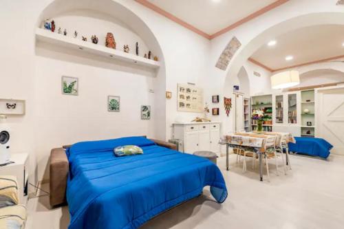 Un dormitorio con una cama azul y una mesa en Loft incantevole all'obelisco en Roma