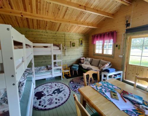 Pokój z 2 łóżkami piętrowymi i stołem w obiekcie Satukurki-vierasmaja - Simple and Cute Cabin w mieście Sastamala