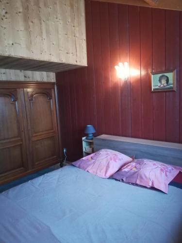 a bed in a room with a red wall at Gîte la ferme de Baffour in La Chaise-Dieu