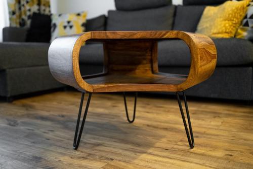 a wooden chair in a living room with a couch at Brick House Premium Apartments in Wrocław
