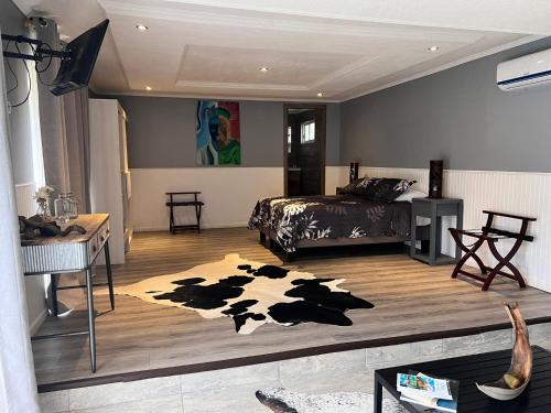 a bedroom with a cow rug on the floor at Inaki Uhi Hotel in Hanga Roa