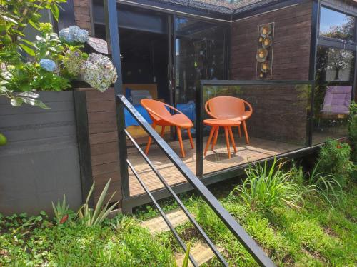 a house with two chairs and a table on a porch at Glamping Montecarlo Lodge Cubo de Madera-Guatapé in Guatapé