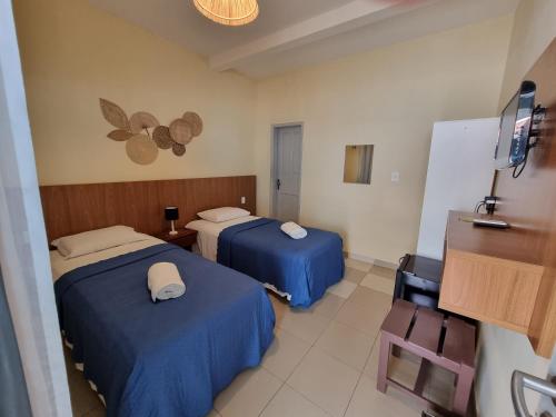 um quarto de hotel com duas camas e uma mesa em Casa Swell Hostel em Fernando de Noronha