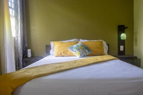 uma cama com lençóis brancos e almofadas amarelas em Mountain View Vacation Home 
