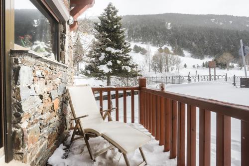 ein weißer Stuhl auf einem Balkon im Schnee in der Unterkunft Appartement Chalet Vall d Incles Résidence Deu Sol in Canillo