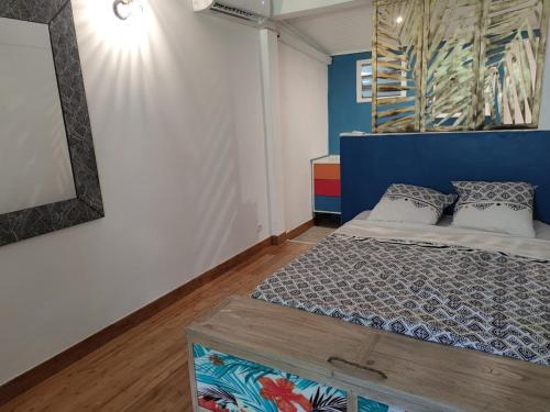 - une chambre avec un lit et un mur bleu dans l'établissement Rêves de rivière- fonctionnel et bien placé, à Le Carbet