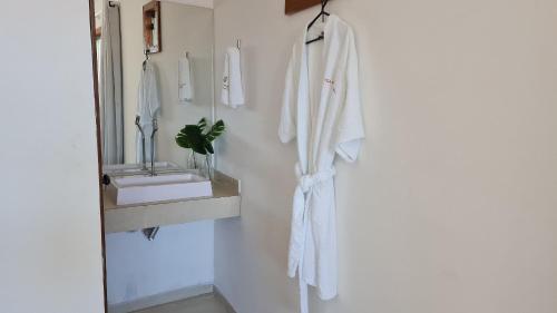 a bathroom with a white towel hanging on a wall at Vila Pitangueira - Flat Terra - No centro de Serra Grande com Piscina, Jacuzzi, Internet Veloz in Serra Grande