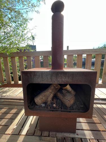 a stone oven with logs in it on a deck at NEW - Private Cabin - on a lake near Amsterdam in Vinkeveen