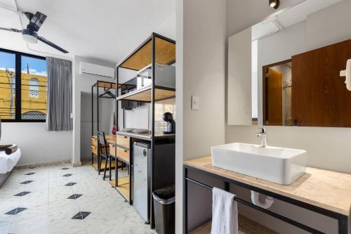 een badkamer met een witte wastafel en een aanrecht bij Suites Reforma by HomiRent in Mérida