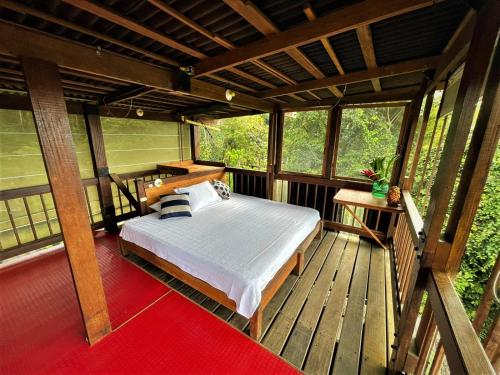 a bedroom with a bed on a wooden deck at La Kuka Hotel - Nuquí in Nuquí