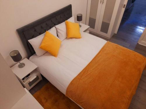 um quarto com uma cama grande e almofadas amarelas em Modern flat near city centre. em Edimburgo