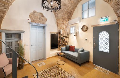 a living room with a chair and a couch and a door at Villa Sera in ‘Akko