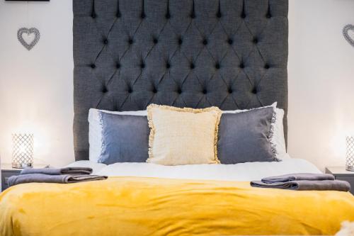 a bedroom with a large bed with a black headboard at Dealhouse Apartments 11 in Huddersfield