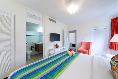 a bedroom with a white bed with a colorful blanket at La Vista Beach Resort in Simpson Bay