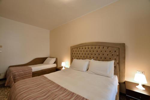 a hotel room with two beds and two lamps at Hotel Ristorante La Marina Mhotelsgroup in San Bartolomeo al Mare