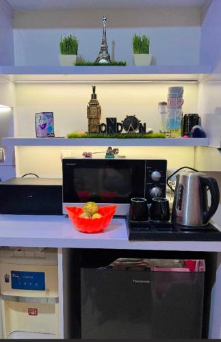 a kitchen counter with a microwave and a bowl of food at Homestay Jakarta in Pondokcabe Hilir