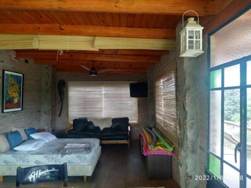 1 dormitorio con 2 camas y 1 sofá en una habitación en Cabaña LA PEDRERA - Pileta y a metros del Rio en Bialet Massé