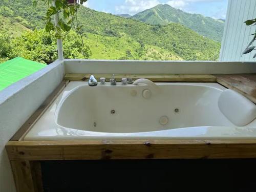 a white bath tub in a bathroom with a window at Casa Bali PR in Guayama