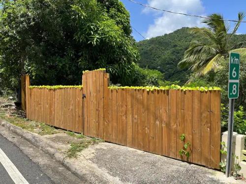 a wooden fence on the side of a road at Casa Bali PR in Guayama