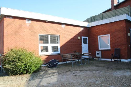 a brick building with a patio with a table and chairs at Skjernaa-ferie/ Andersen Invest in Skjern