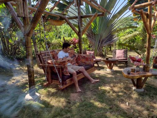 a man sitting in a chair under a gazebo at Sexto Sentido Cabañas & Pan Frances in Palomino