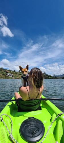 a woman and a dog on a raft in the water at Glamping Montecarlo Lodge Cubo de Madera-Guatapé in Guatapé
