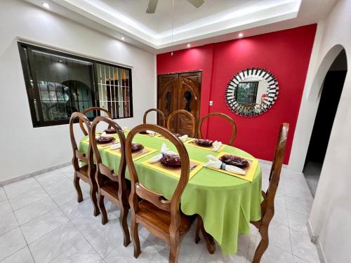 a dining room with a green table and chairs at Solar Energy Presidential Suite in Minatitlán