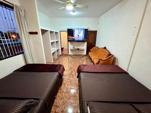 a living room with two leather couches and a flat screen tv at Solar Energy Presidential Suite in Minatitlán