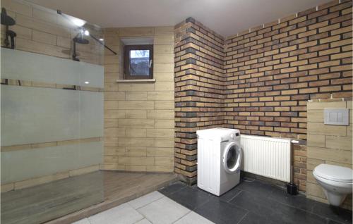 a bathroom with a toilet and a brick wall at 8 Bedroom Awesome Home In Kamien in Kamień