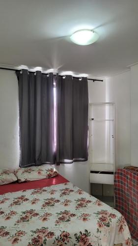 1 dormitorio con cama y cortina negra en Ótimo Ap na Pajuçara - Maceió, en Maceió