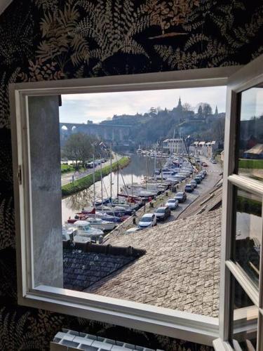 a window view of a marina with boats in the water at Escapade sur le port de Dinan in Dinan