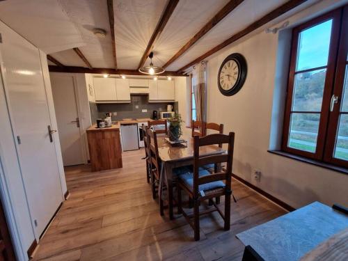 a kitchen with a table and chairs and a clock on the wall at Escapade sur le port de Dinan in Dinan