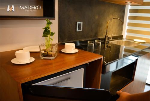 a kitchen with a counter with dishes and a sink at Madero Hotel & Suites in La Paz