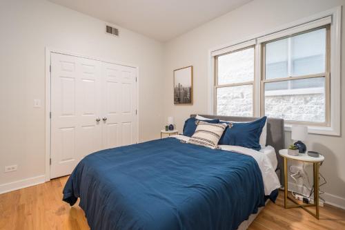 a bedroom with a blue bed and a window at Vibrant and Modern 2-Bedroom Home Near Downtown in Chicago