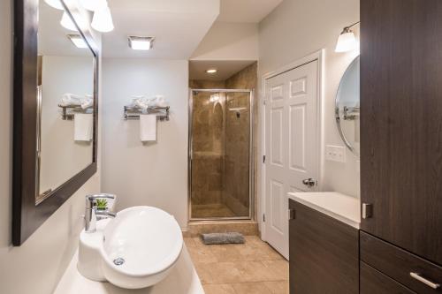 a bathroom with a toilet and a sink and a shower at Vibrant and Modern 2-Bedroom Home Near Downtown in Chicago