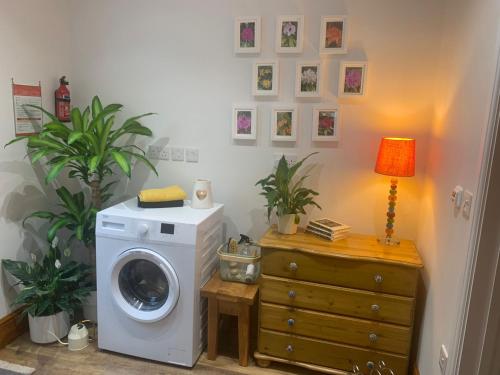 a laundry room with a washing machine and a lamp at Hilltop Cottage in Thropton