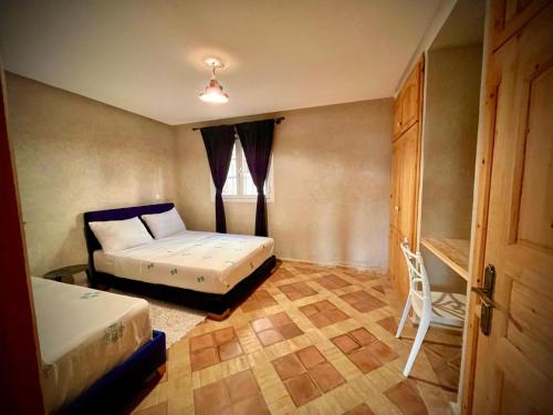 a small bedroom with two beds and a window at Dar diafa samira in Mirleft
