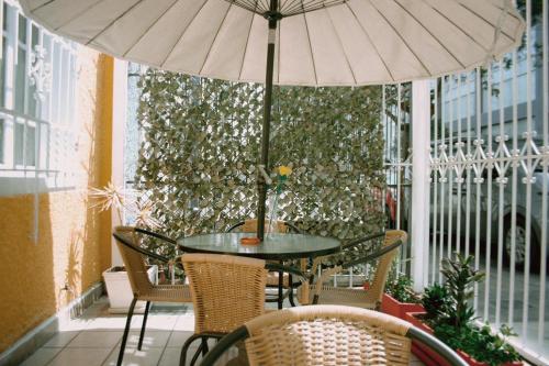 una mesa y sillas con una sombrilla en el patio en Lion Backpackers, en Lima