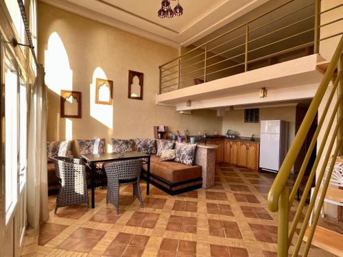 a kitchen and living room with a table and chairs at Dar diafa samira in Mirleft