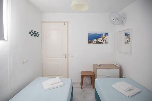 ティロスにあるKarantouのベッドルーム1室(ベッド2台、テーブル、ドア付)