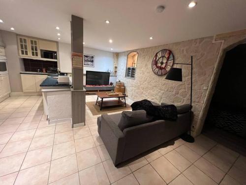 uma sala de estar com um sofá e uma cozinha em Les 4 chênes - T2 refait à neuf em Le Pont-de-Beauvoisin